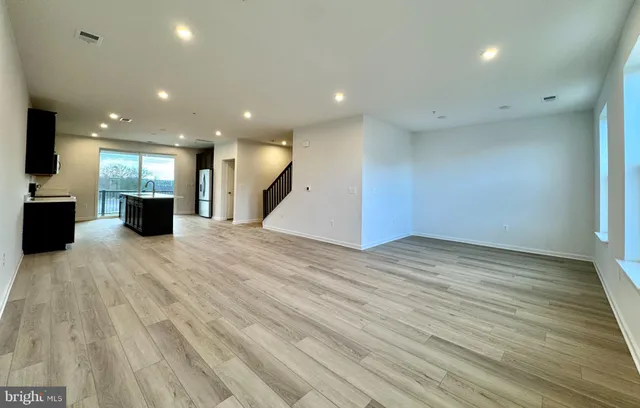 a view of a large kitchen with a large counter top and stainless steel appliances