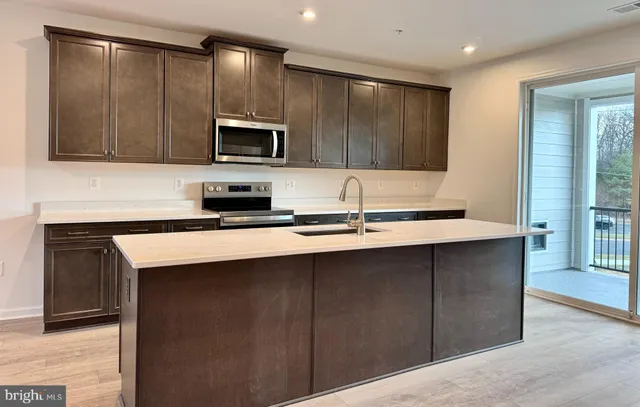 a kitchen with stainless steel appliances granite countertop a sink a stove and a microwave