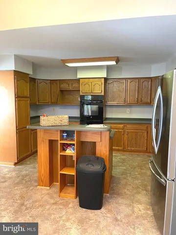 a kitchen with stainless steel appliances granite countertop a refrigerator stove top oven and sink
