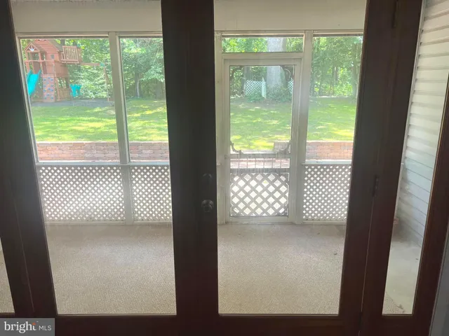 a view of empty room with wooden floor and windows