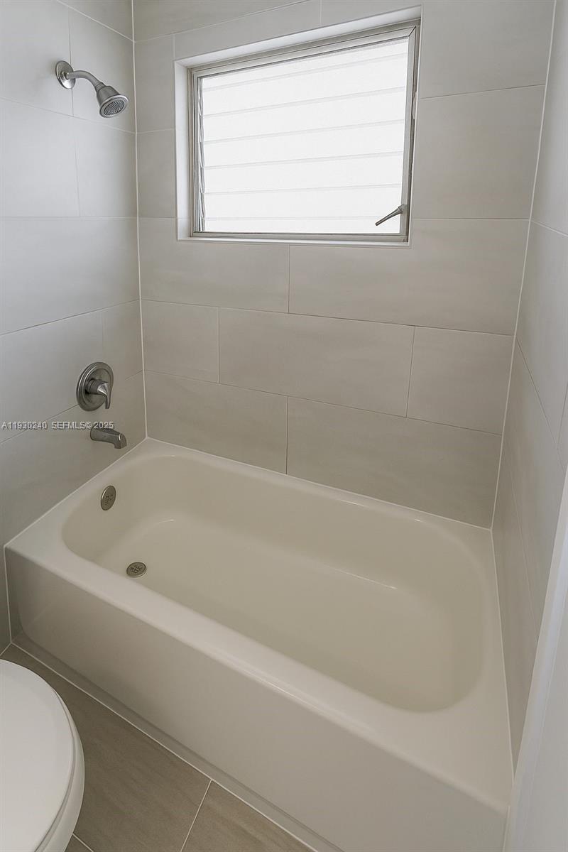 749 Southeast 15th Street, Unit 8 Fort Lauderdale, FL 33316 - Photo 12 of 15 a bath tub sitting next to a white sink and a toilet