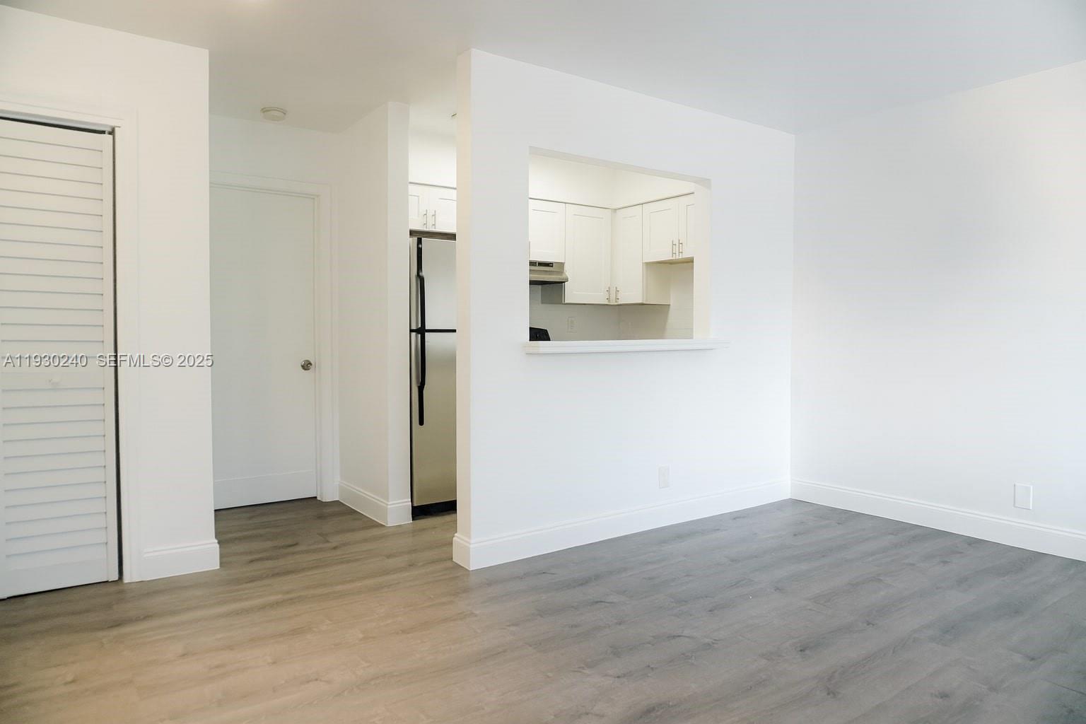 749 Southeast 15th Street, Unit 8 Fort Lauderdale, FL 33316 - Photo 3 of 15 an empty room with wooden floor and a bathroom