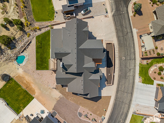 1192 East Ashdown Road Cedar City, UT 84721 - Photo 18 of 96 Multiple-pitch roofline, gravel landscaping, manicured lawn areas, curved driveway, and a distinct turquoise-colored pool