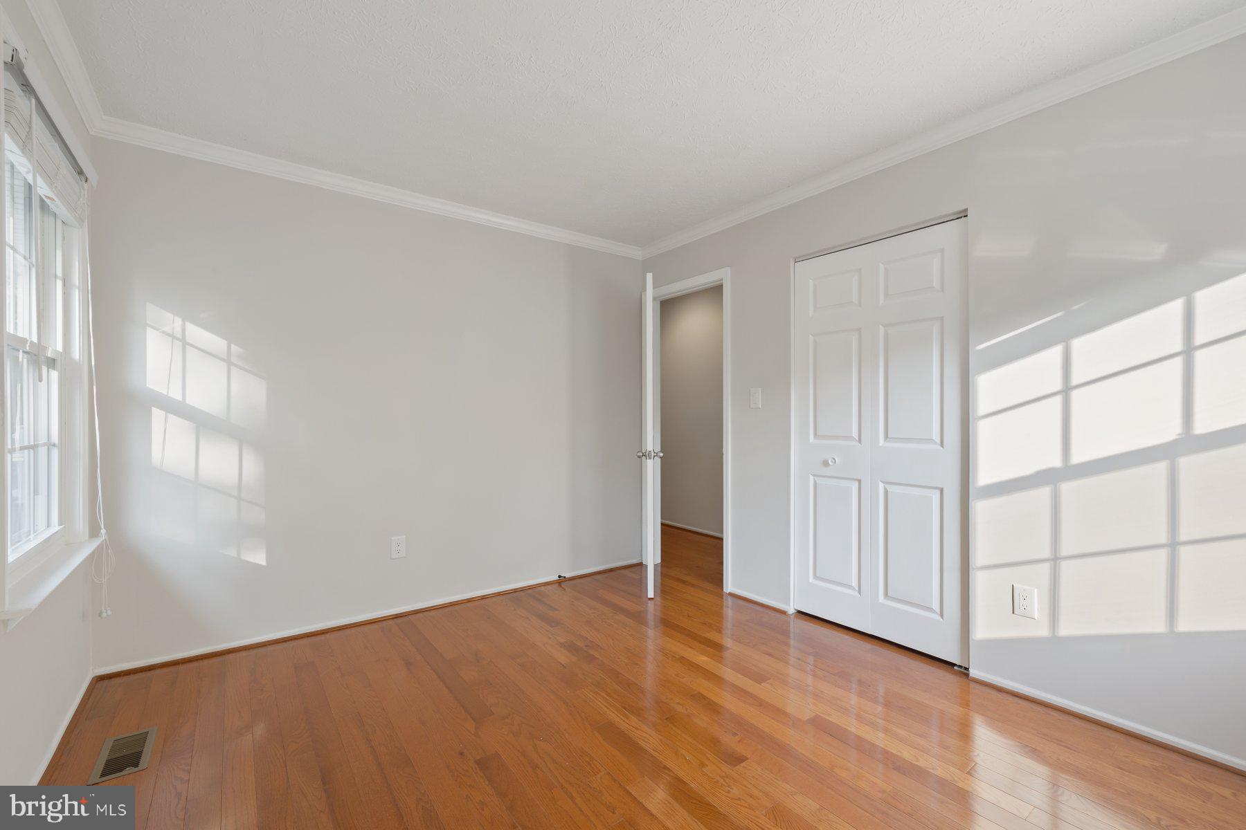 8304 Grainfield Road Severn, MD 21144 - Photo 15 of 49 a view of an empty room with wooden floor and a window