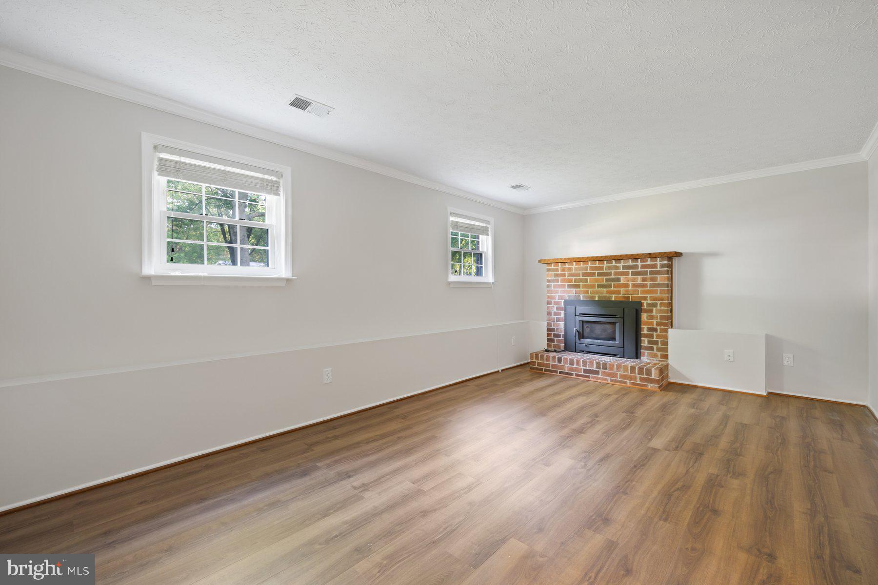 8304 Grainfield Road Severn, MD 21144 - Photo 18 of 49 an empty room with wooden floor and windows