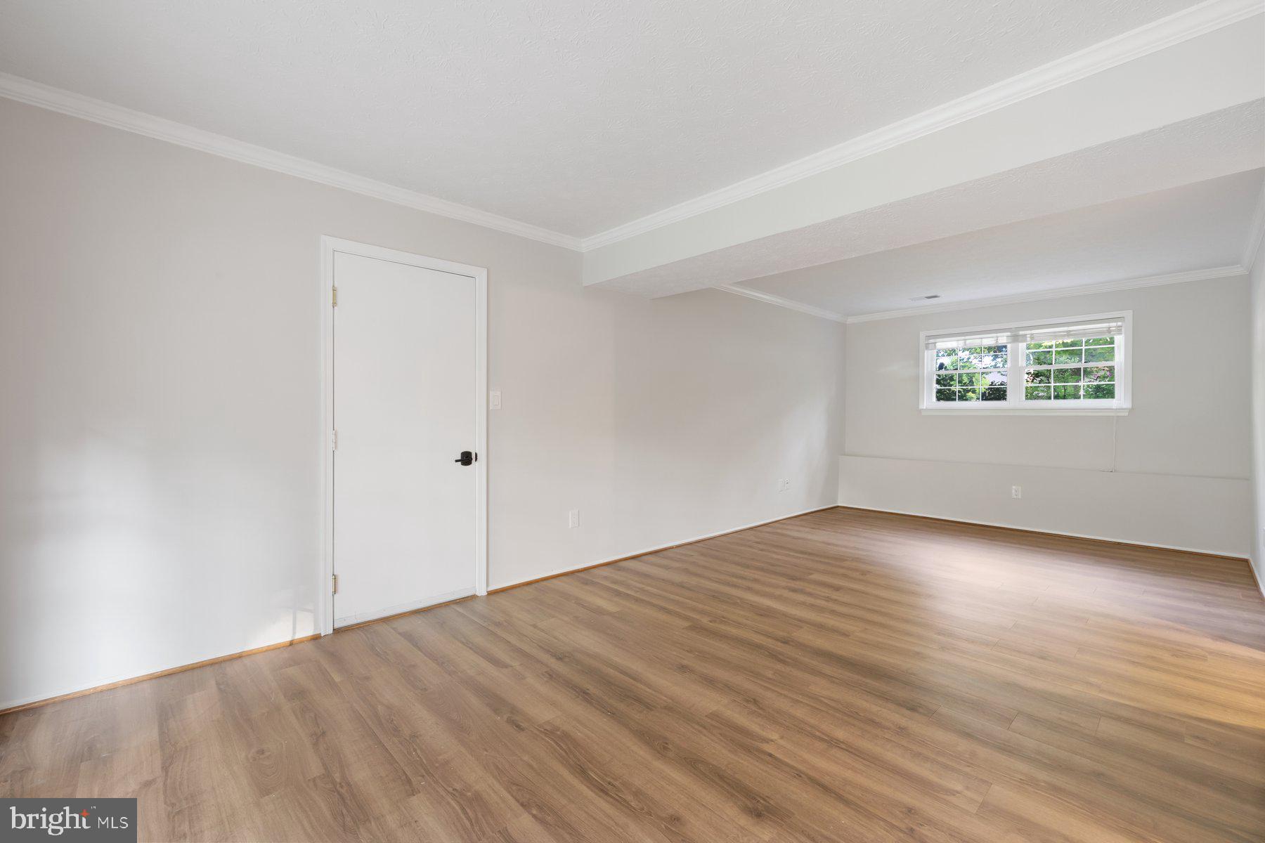 8304 Grainfield Road Severn, MD 21144 - Photo 22 of 49 an empty room with wooden floor and windows
