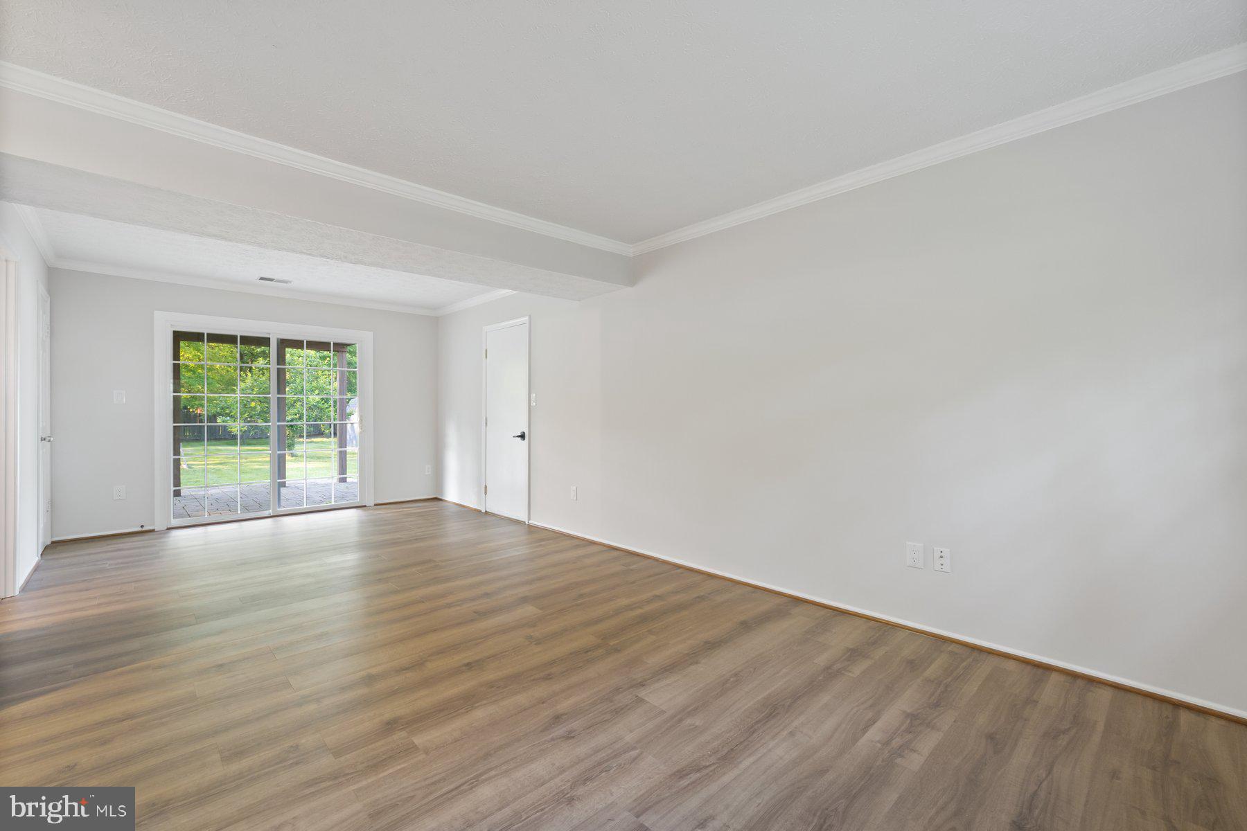 8304 Grainfield Road Severn, MD 21144 - Photo 23 of 49 a view of an empty room with wooden floor and a window