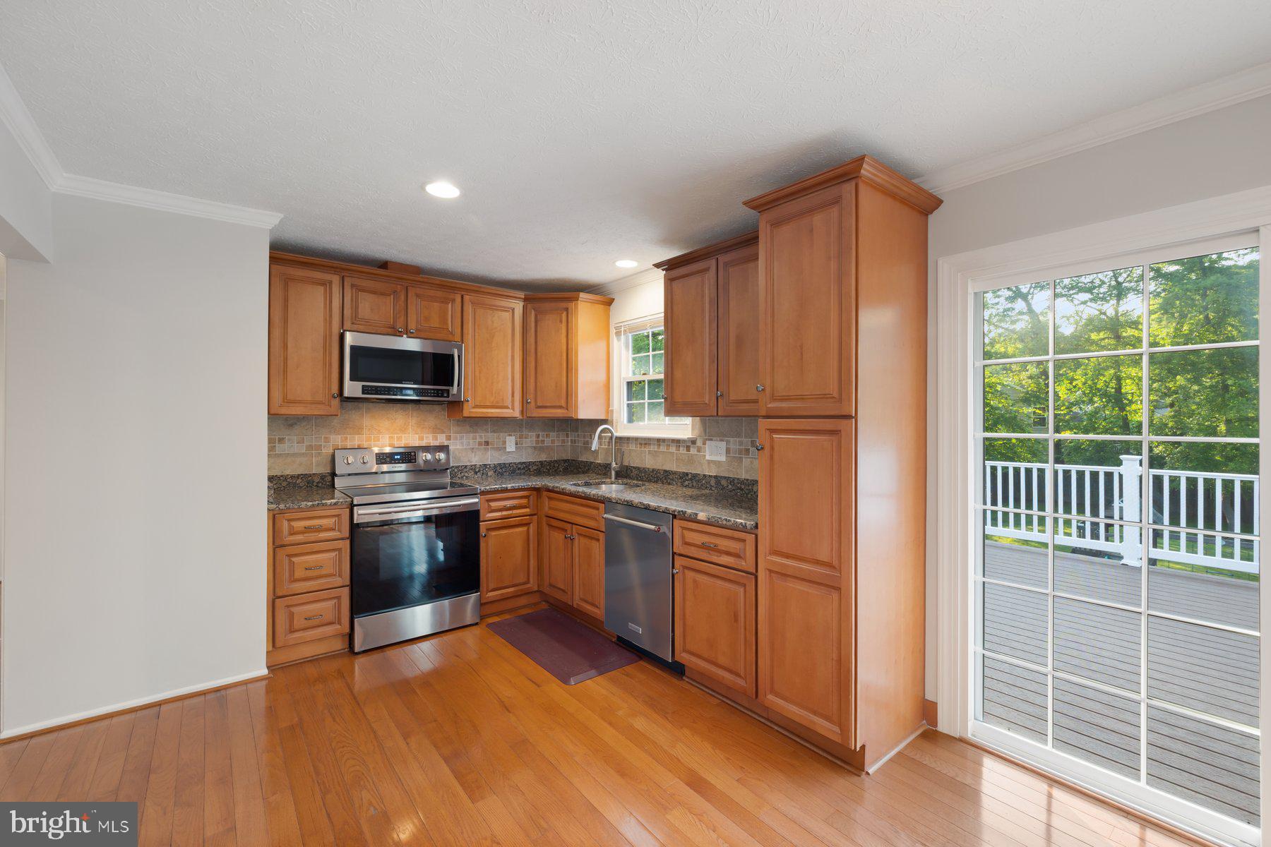 8304 Grainfield Road Severn, MD 21144 - Photo 3 of 49 a kitchen with stainless steel appliances granite countertop a refrigerator a stove top oven and sink