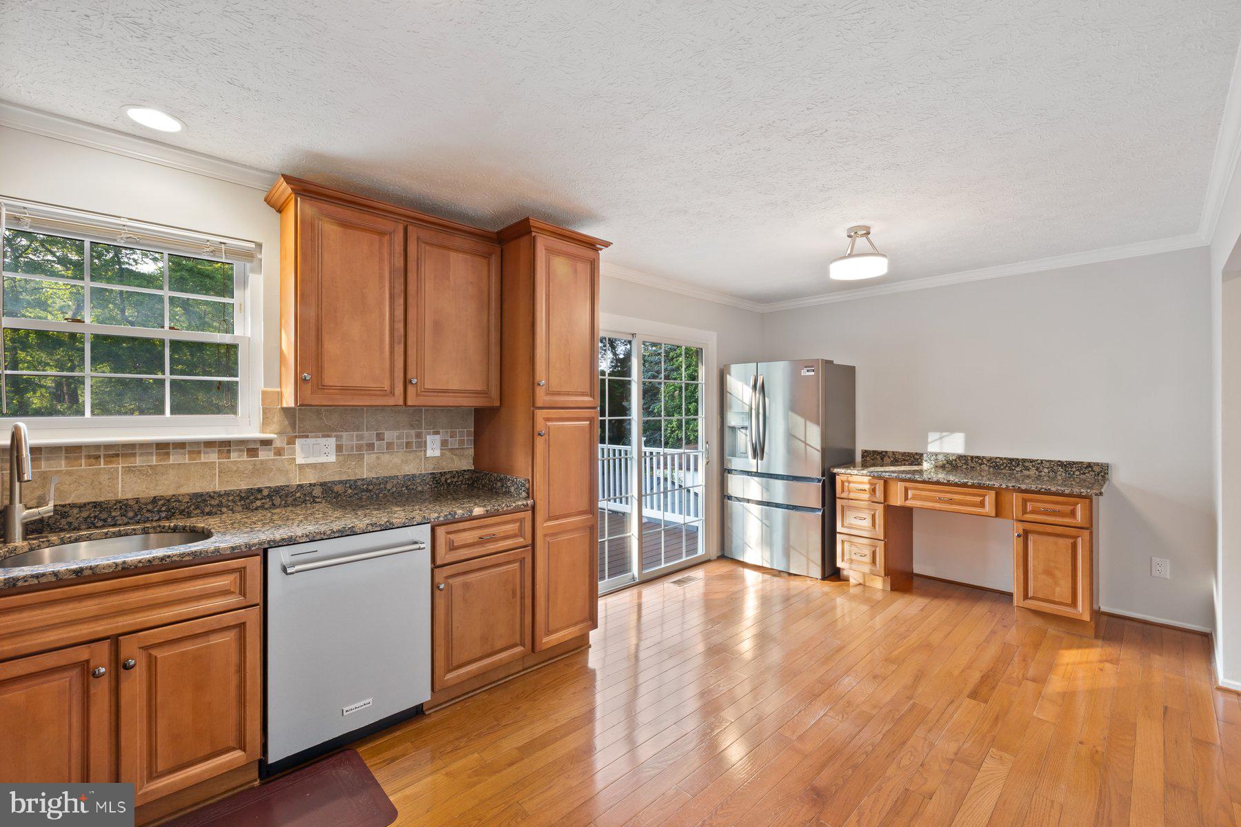8304 Grainfield Road Severn, MD 21144 - Photo 4 of 49 a kitchen with stainless steel appliances granite countertop a stove a sink dishwasher and a refrigerator with wooden floor