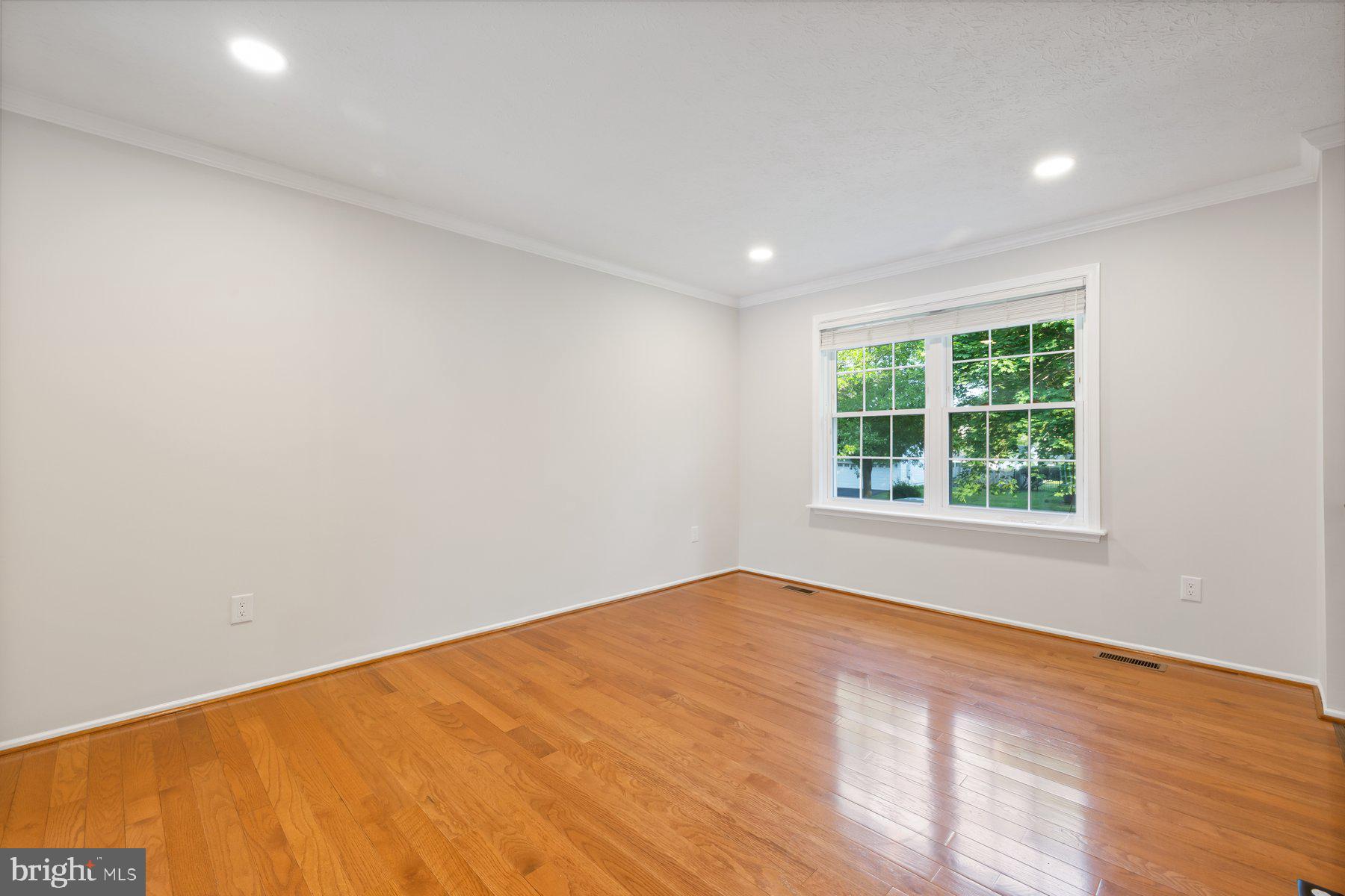 8304 Grainfield Road Severn, MD 21144 - Photo 10 of 49 an empty room with wooden floor and windows