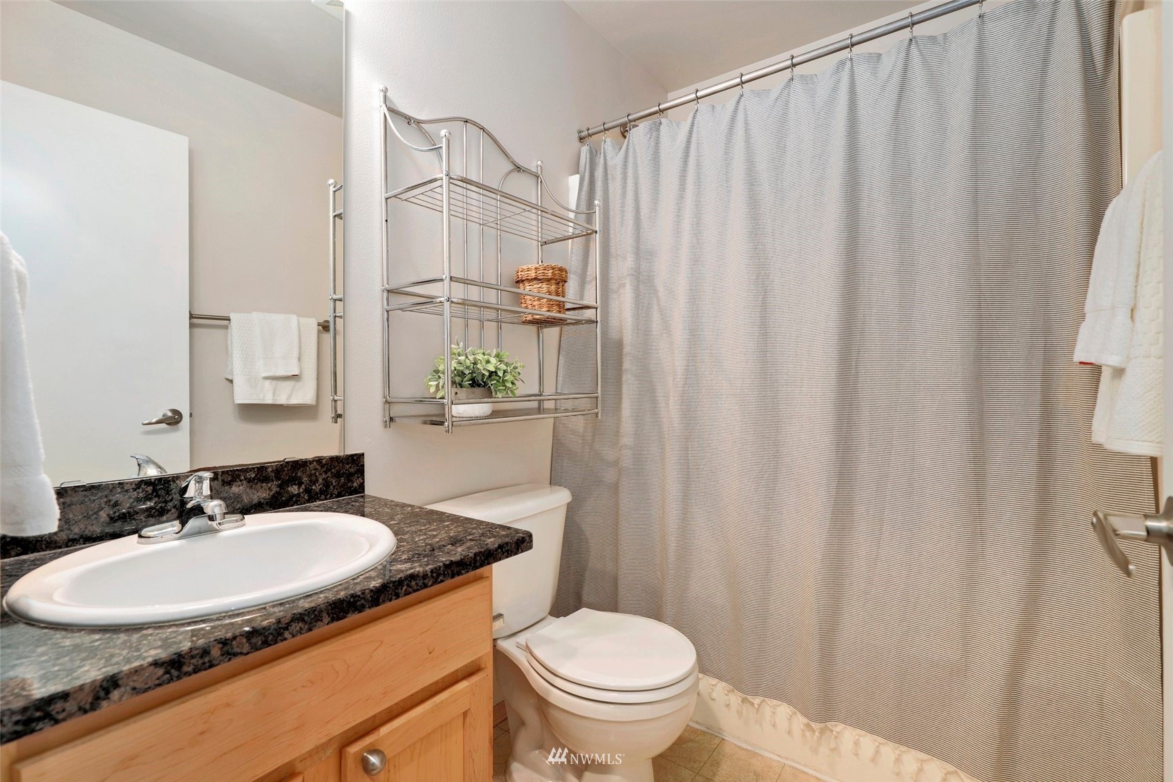 1322 196th Place Southeast Bothell, WA 98012 - Photo 20 of 40 a bathroom with a sink toilet a mirror and shower curtain