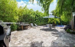 635 Curtiswood Drive Key Biscayne, FL 33149 - Photo 18 of 22 a view of backyard with swimming pool and sitting area