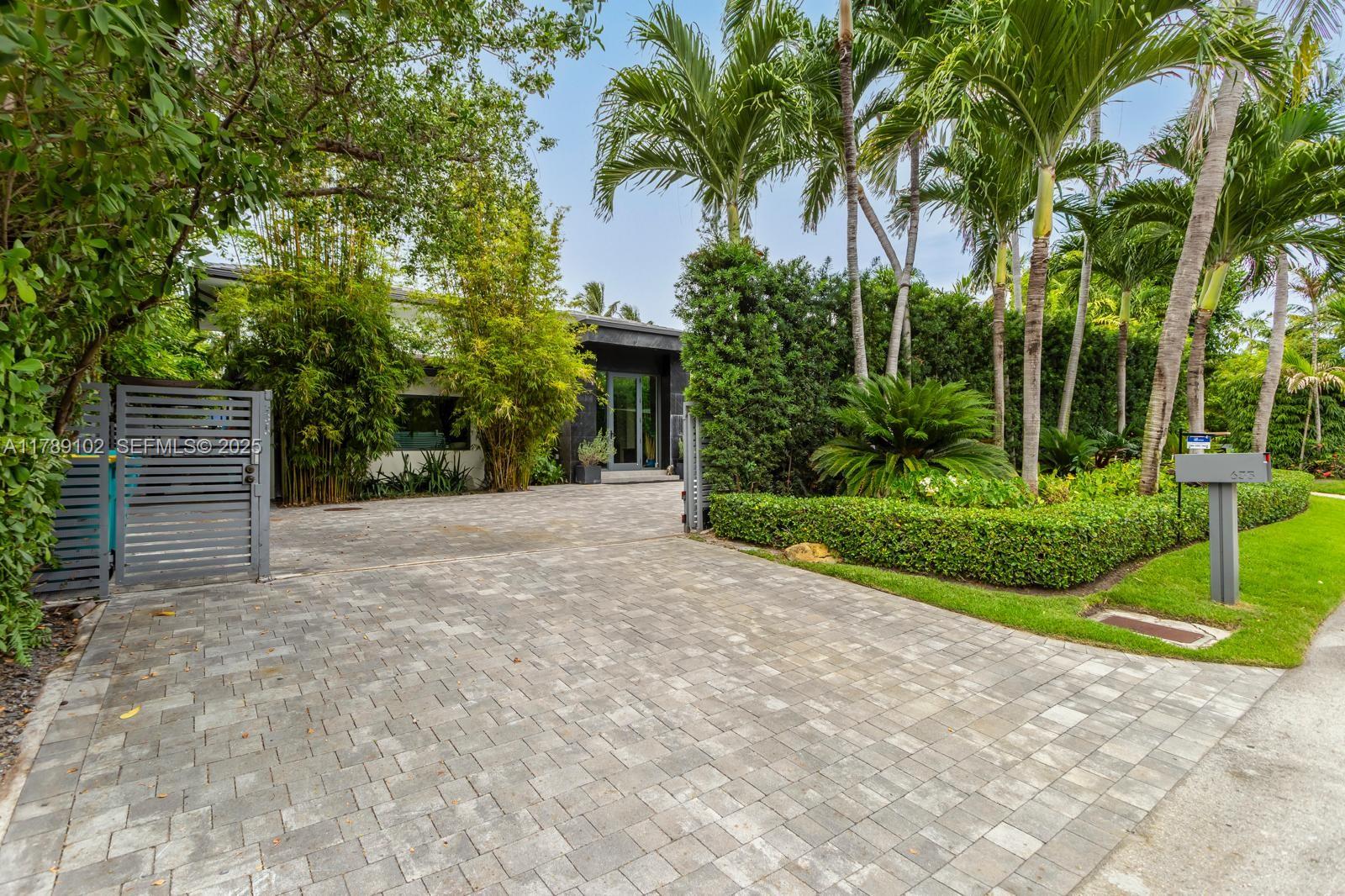 635 Curtiswood Drive Key Biscayne, FL 33149 - Photo 2 of 22 a view of a house with a yard and palm trees