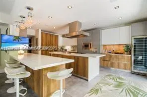 a kitchen with stainless steel appliances kitchen island granite countertop a table and chairs in it