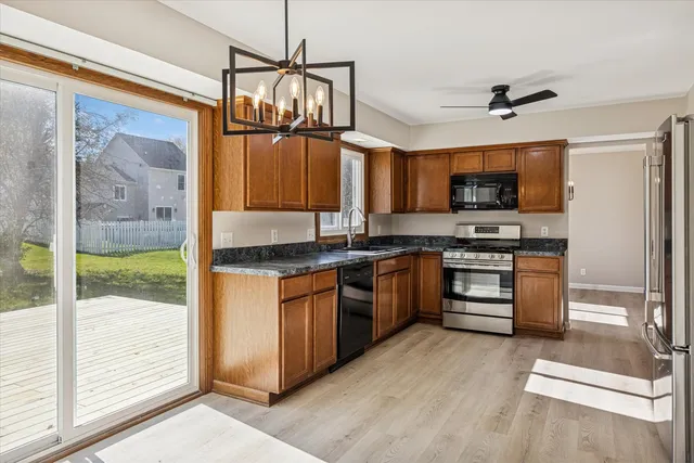 a kitchen with stainless steel appliances granite countertop a stove a sink and a refrigerator