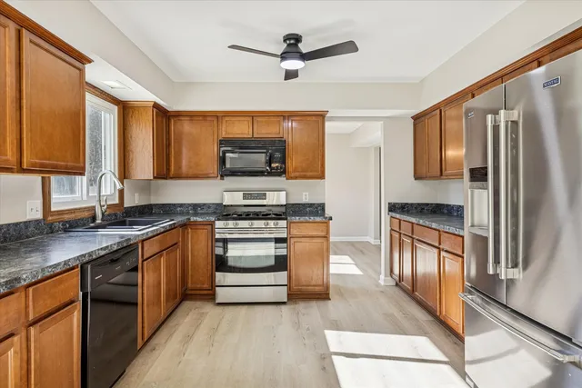 a kitchen with stainless steel appliances a stove a sink and a refrigerator