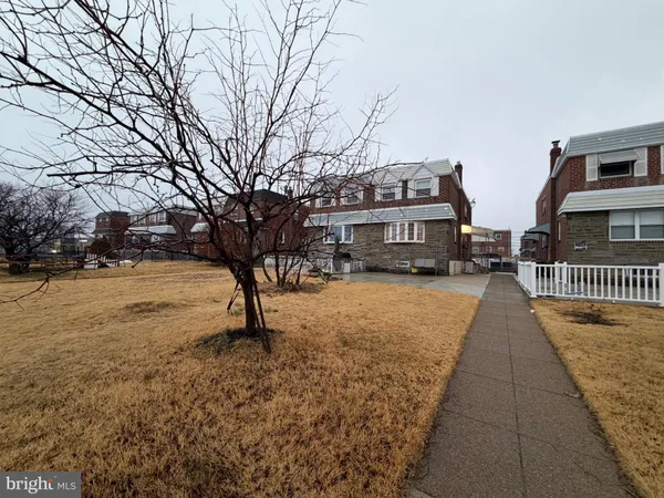 a view of residential houses with yard and car parked
