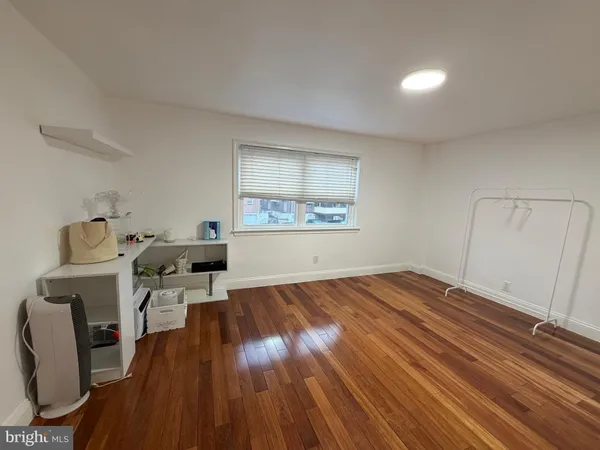 a view of a workspace with wooden floor and a window