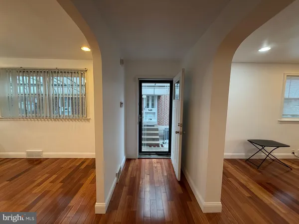 a view of a hallway with wooden floor and staircase