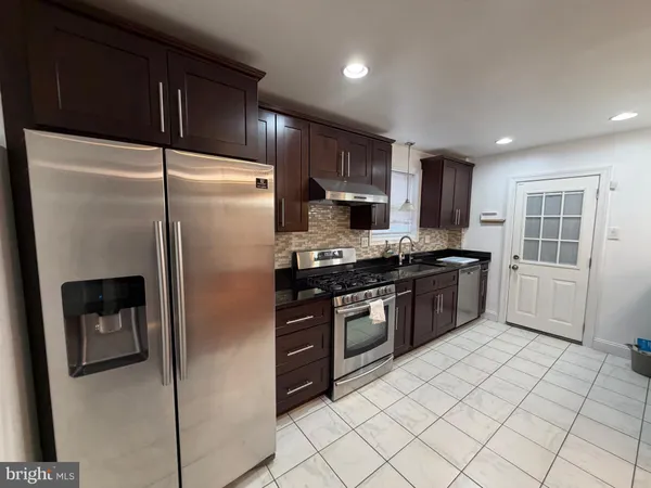 a kitchen with stainless steel appliances granite countertop a refrigerator and a sink