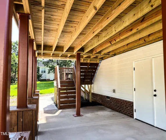 a view of a porch with wooden floor in front of a house