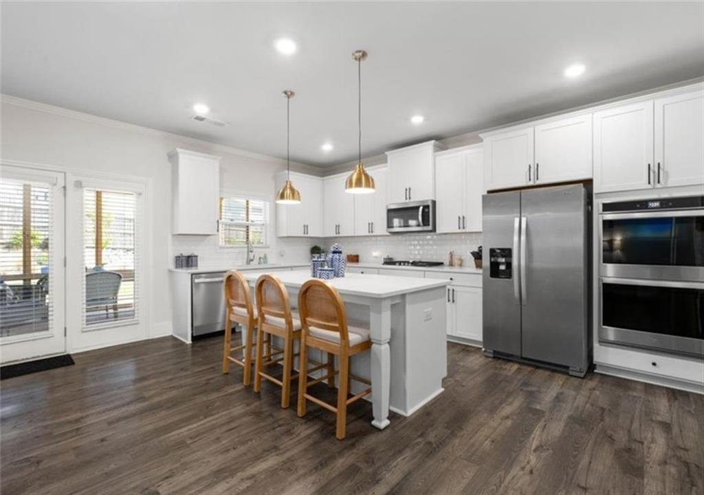 146 Citrine Way Acworth, GA 30101 - Photo 13 of 48 a kitchen with stainless steel appliances granite countertop a refrigerator a stove top oven a sink dishwasher and white cabinets with wooden floor