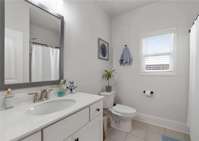 a bathroom with a granite countertop toilet a sink and a mirror