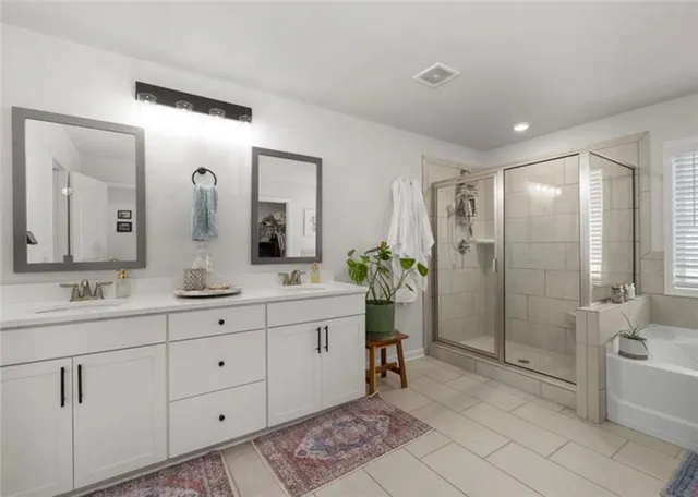 a bathroom with a double vanity sink mirror and bathtub