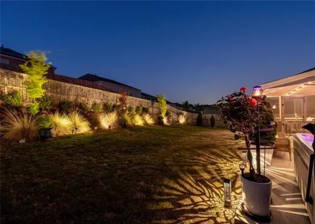 a view of a yard with plants and a fountain