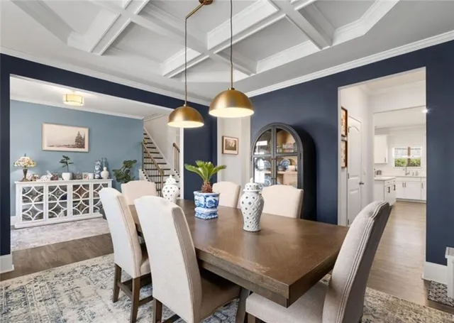 a dining room with wooden floor a chandelier a wooden table and chairs