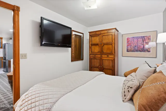 a bedroom with a large bed and a flat screen tv