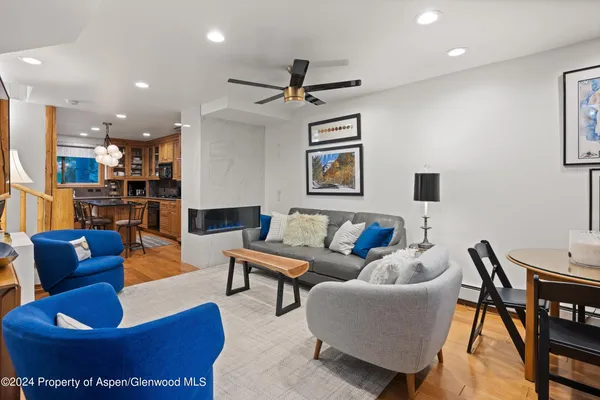 a living room with furniture and a view of kitchen