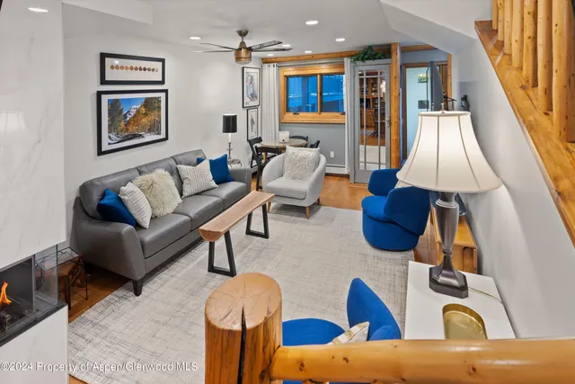 a living room with furniture a rug and white walls