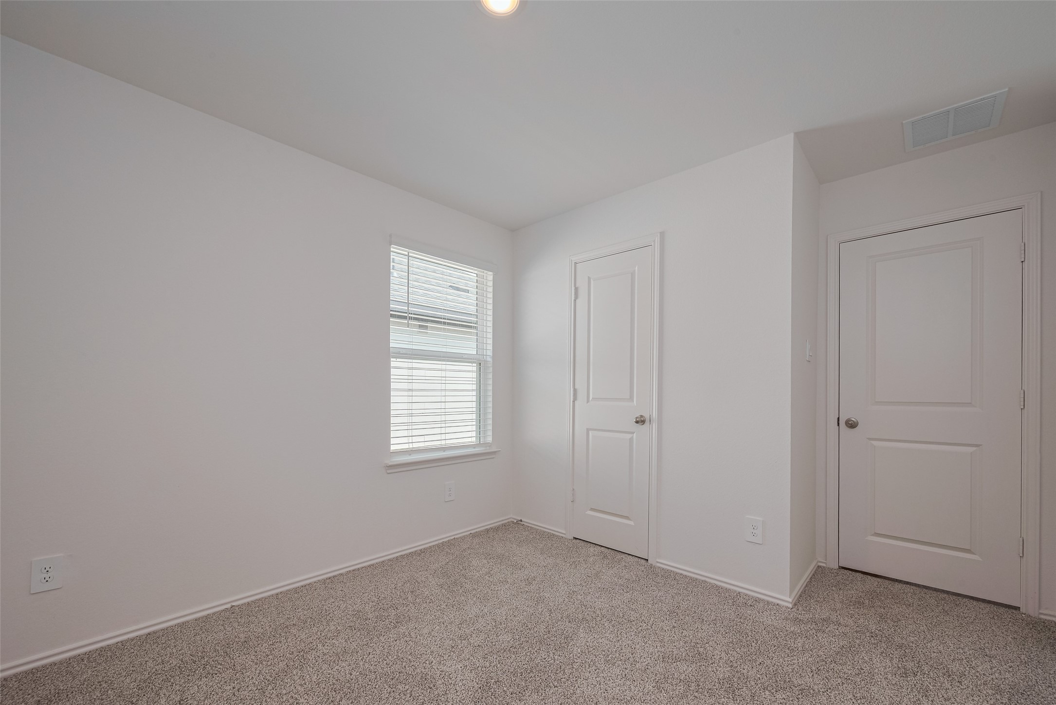 30910 Rockstock Road Fulshear, TX 77441 - Photo 19 of 33 The third bedroom mirrors the home’s cohesive style, with warm carpeting underfoot and a large window welcoming in natural light.