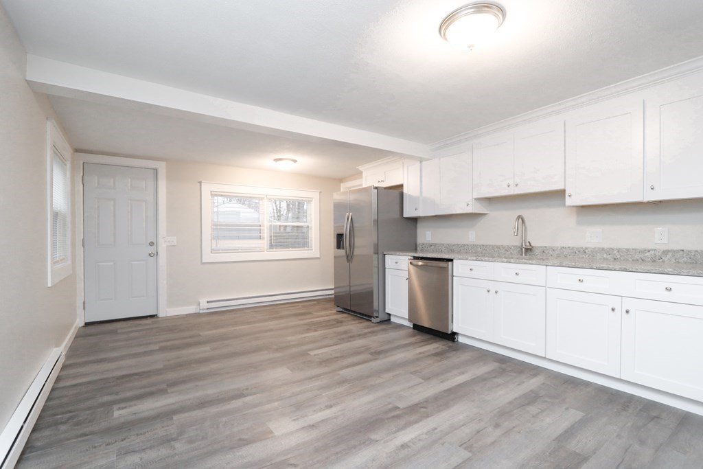 40 Vincent Street Springfield, MA 01129 - Photo 11 of 35 a kitchen with granite countertop white cabinets and white appliances