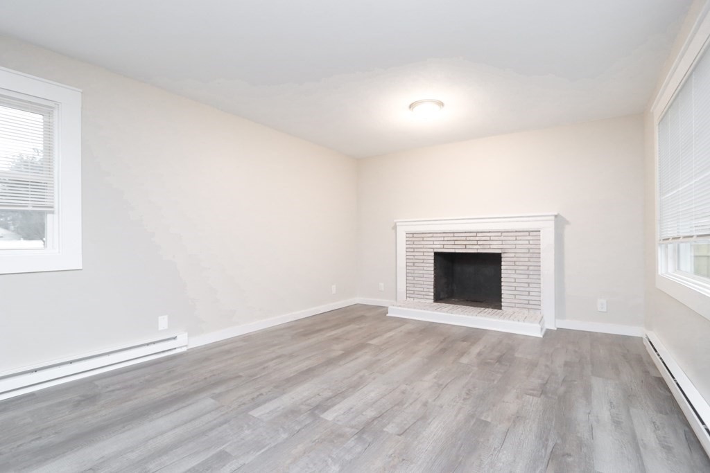 40 Vincent Street Springfield, MA 01129 - Photo 4 of 35 an empty room with wooden floor and fireplace
