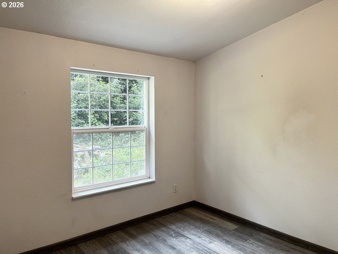 83411 Clear Lake Road Florence, OR 97439 - Photo 22 of 47 an empty room with wooden floor and windows