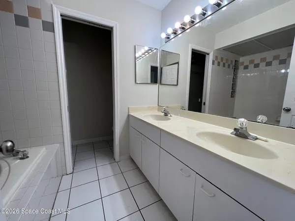 a spacious bathroom with a bathtub sink and mirror