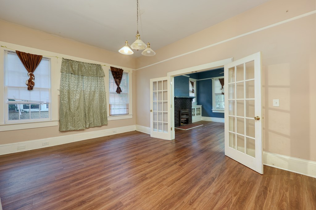 2904 Beacon Avenue Columbus, GA 31904 - Photo 24 of 39 an empty room with wooden floor chandelier and windows