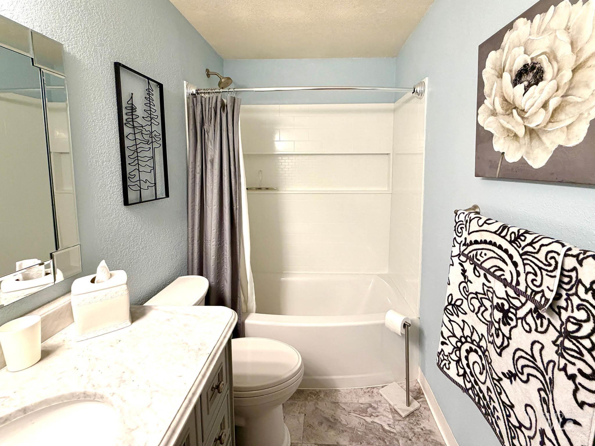 3920 North Maple Grove Road Boise, ID 83704 - Photo 22 of 29 Bathroom featuring a white bathtub and shower combination with a curved shower rod