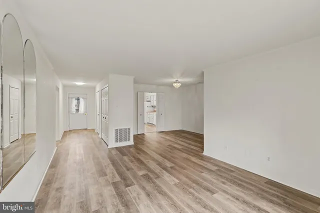 a view of a big room with wooden floor and windows