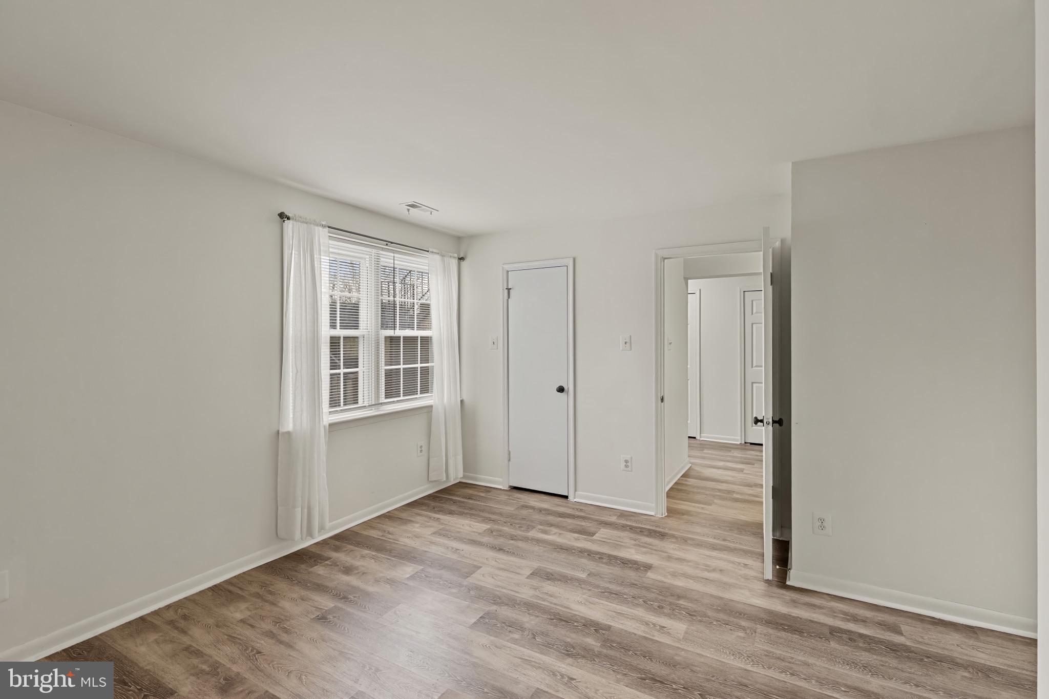 10 Kettle Court, Unit 76F Windsor Mill, MD 21244 - Photo 18 of 29 a view of an empty room with wooden floor and a window