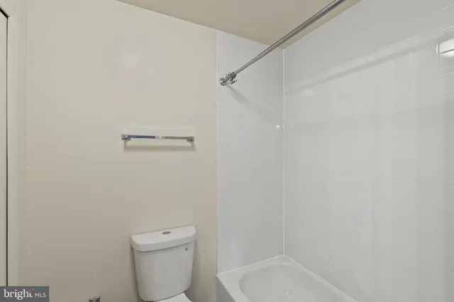 a white toilet sitting next to a bath tub