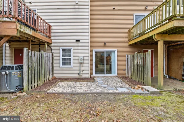 a view of a house with a small yard and wooden fence and a large window