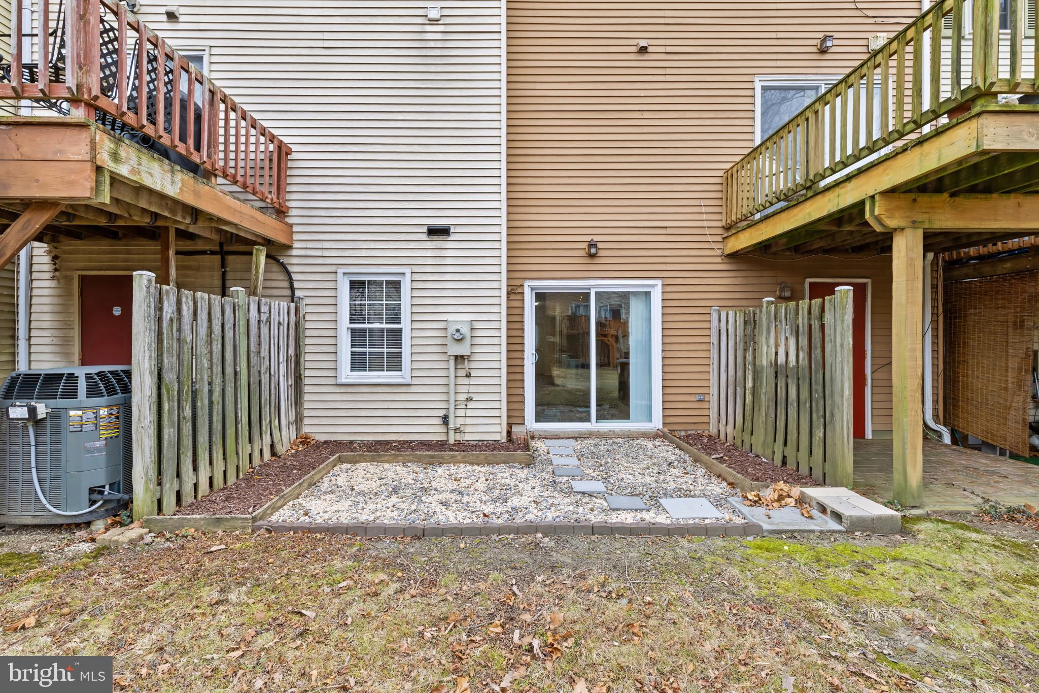 10 Kettle Court, Unit 76F Windsor Mill, MD 21244 - Photo 28 of 29 a view of a house with a small yard and wooden fence and a large window