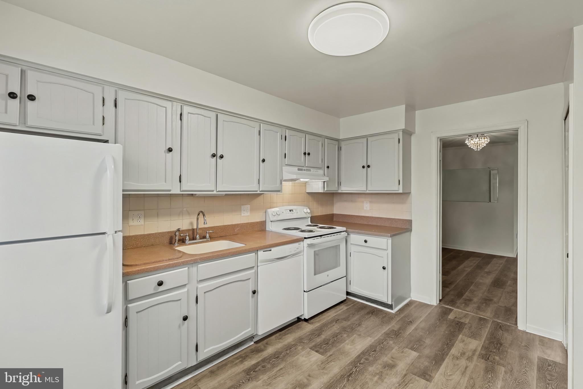 10 Kettle Court, Unit 76F Windsor Mill, MD 21244 - Photo 7 of 29 a kitchen with white cabinets sink and white appliances