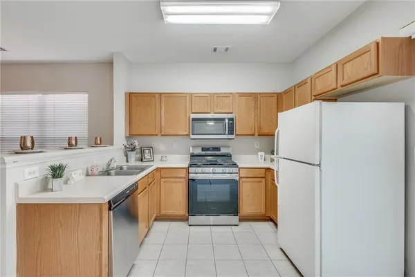 a kitchen with stainless steel appliances granite countertop a refrigerator sink and stove