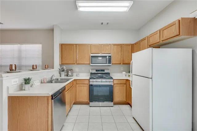 a kitchen with stainless steel appliances granite countertop a refrigerator sink and stove