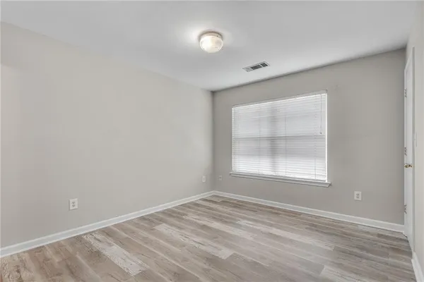 a view of an empty room with wooden floor