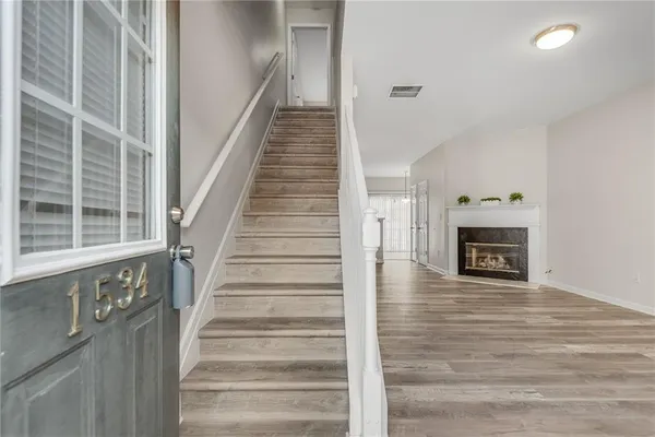 a view of an entryway with wooden floor and a fireplace